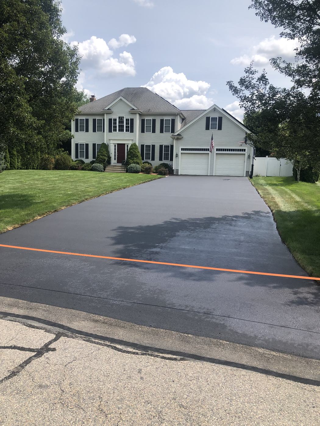 Home driveway with glossy dark sealcoat finish