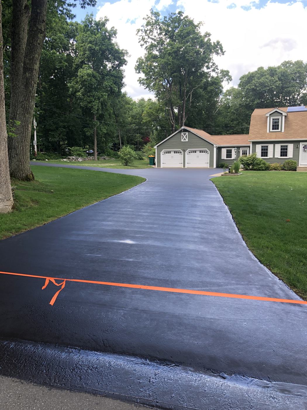 Smooth sealcoated driveway leading to a residential garage