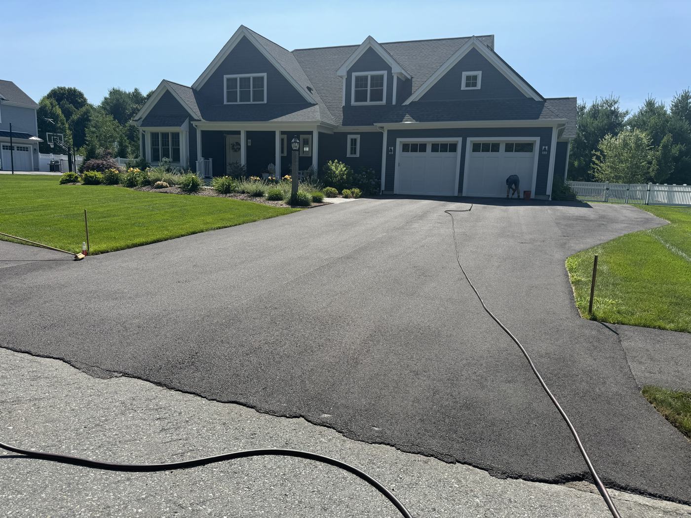 Before-and-after sealcoating transformation on a residential driveway
